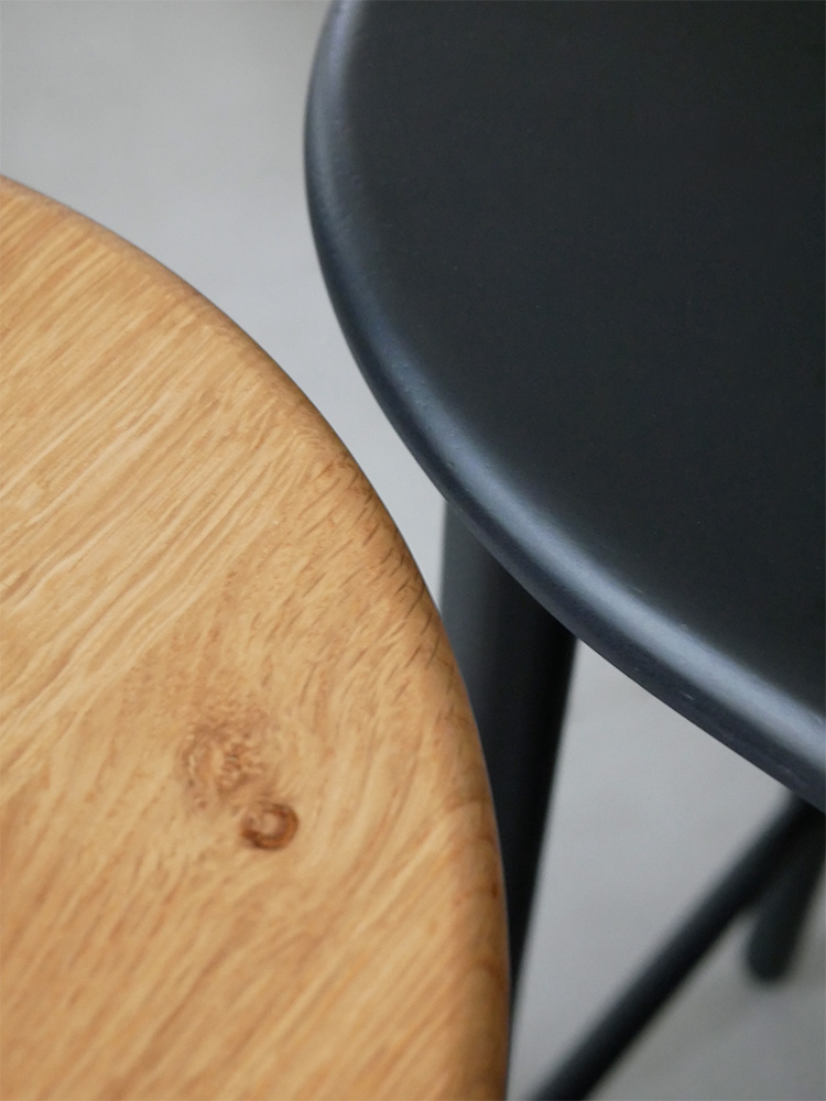 リビングルームに置かれたオーク無垢材の伸長可能なコンソールテーブルとグレーのバースツール