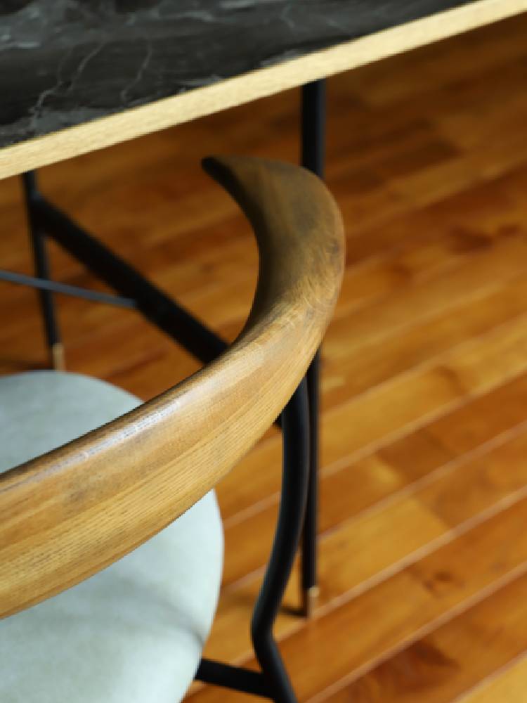 オーク無垢材とスチールフレームを使用したアデペシュのfincチェアが木製の床に置かれている