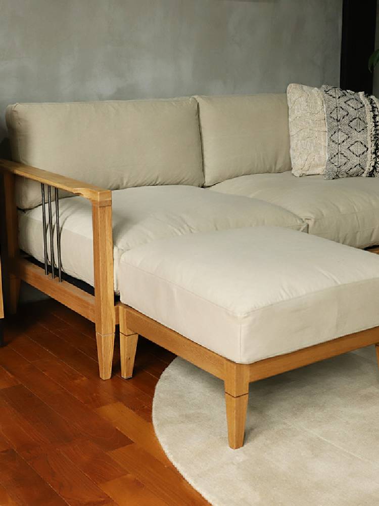 アデペシュのソロ2.5シートソファが木製フロアのリビングルームに配置され、クッションが添えられたインテリアデザイン。