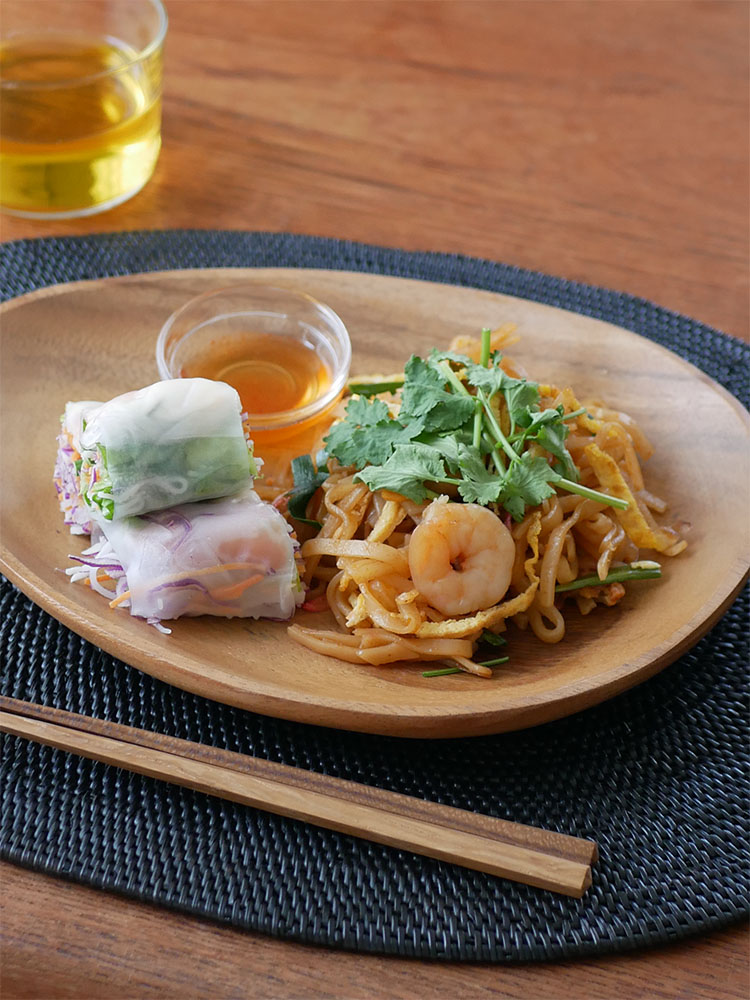 天然木アカシア製のエッグ型トレー、スクエアトレー4仕切り付、ラウンドボールMが料理とともに美しく並べられた食卓の様子