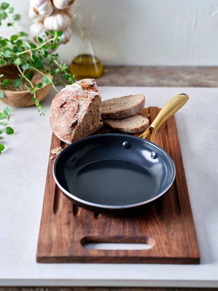 グリーンパンのフライパン、エッグパン、ガラス蓋と食材が並ぶ調理シーンを示す画像です。