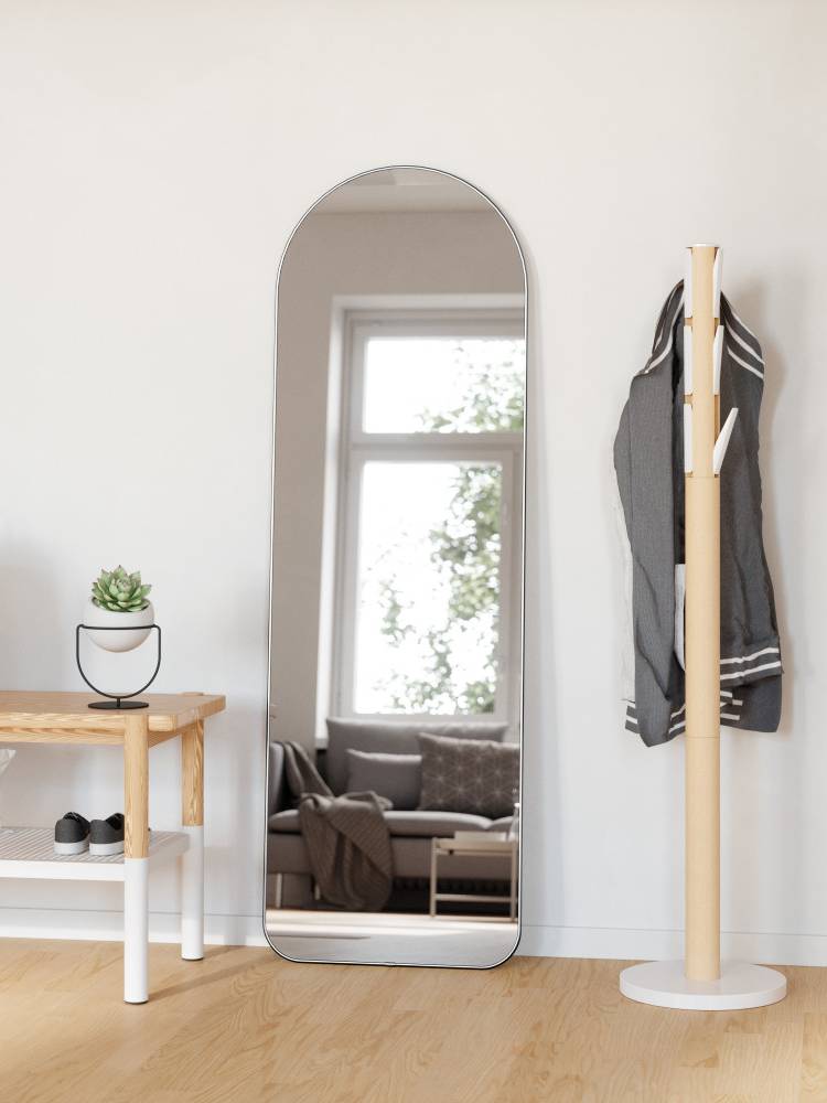 ウムブラのフーバ アーチド リー二ングミラーと写真枠、観葉植物が配置された室内