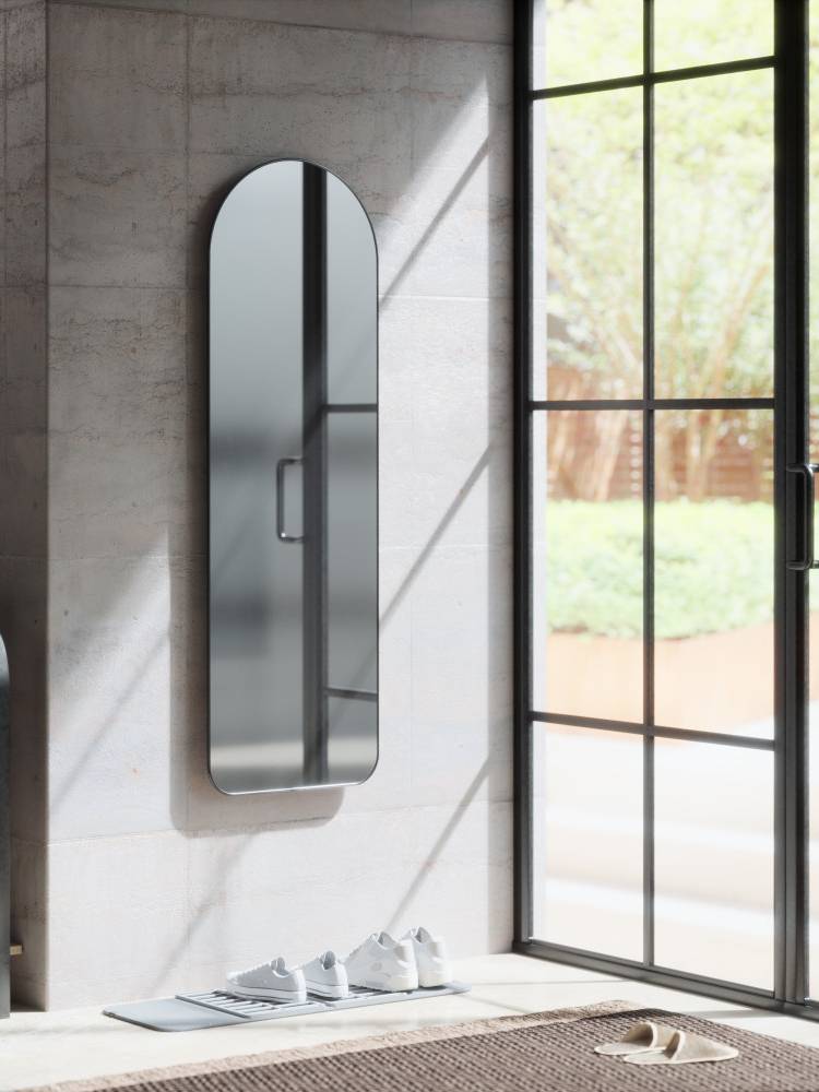 グレーのバスルームに設置されたアンブラのフーバ アーチド リー二ングミラーとシルバーのハンドル。