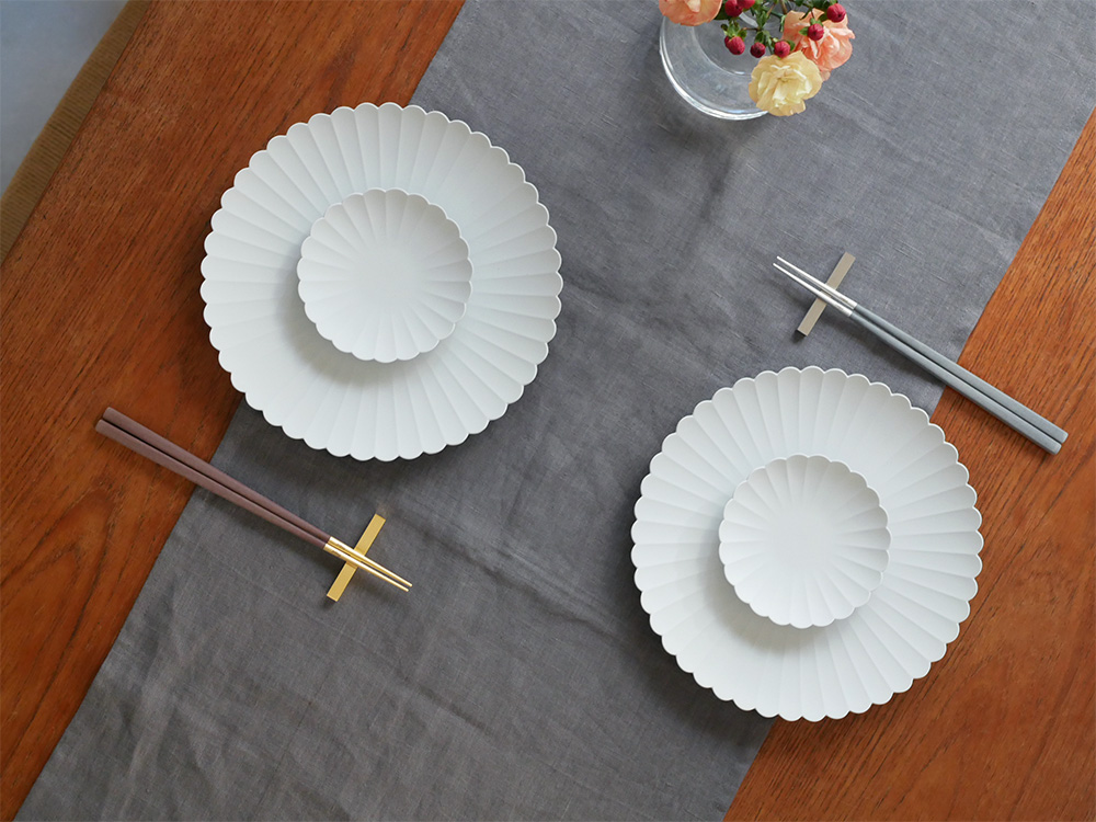 クチポールのKUBEチョップスティック＆レストセット。黒シルバーカラーの天然樹脂製箸と18-10ステンレス製箸置きがテーブルに整然と並べられている