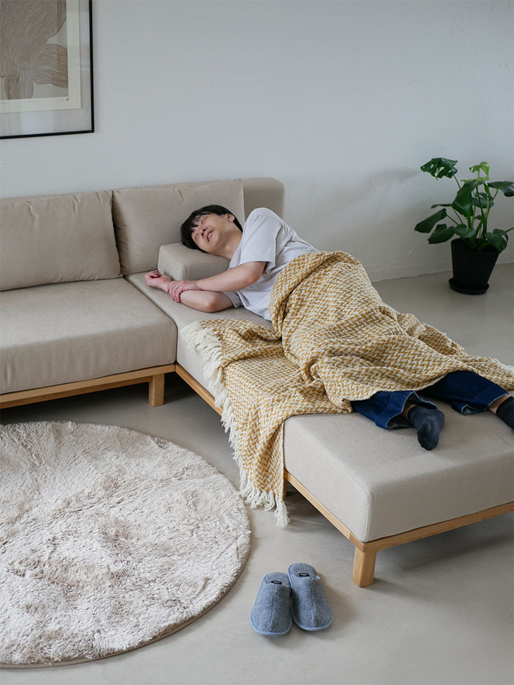 リビングルームに配置された【SIEVE/シーブ】ゆったり座れるレクトユニットソファー。ファブリック張地と木製フレームが特徴で、快適な座り心地を提供します。