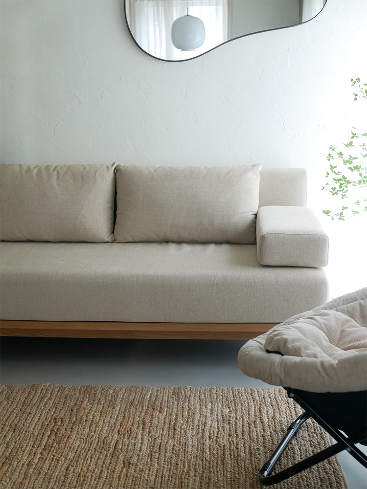 木製の床に配置されたブラウンのゆったり座れるレクトユニットソファーを備えたリビングルームのインテリア