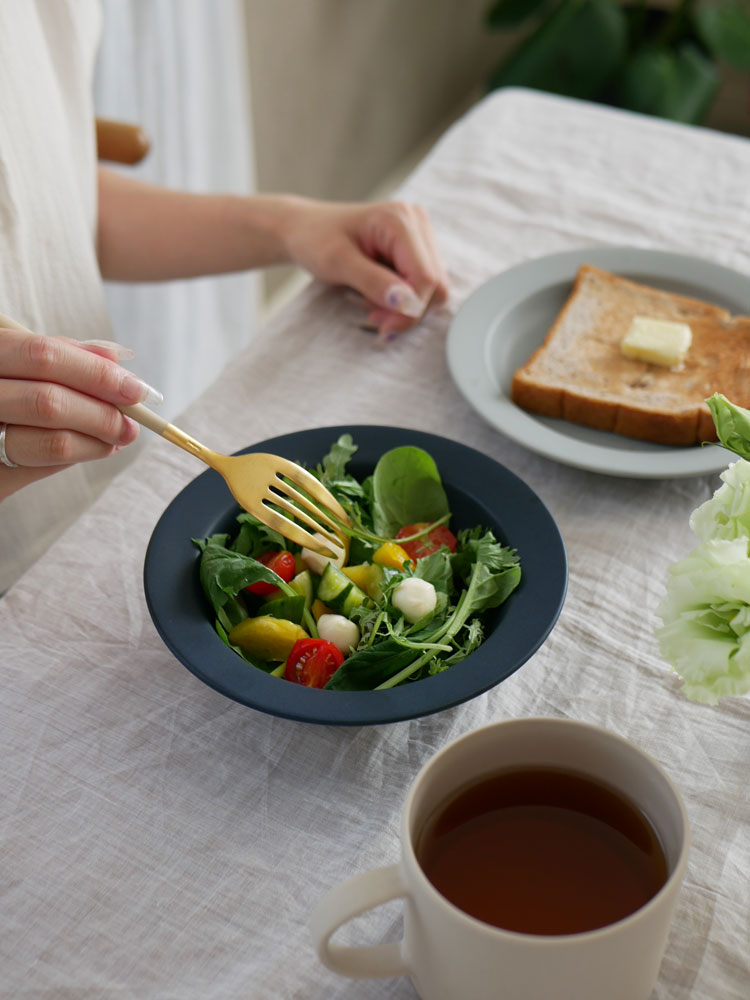 SAKUZANのSaraシリーズ、磁器製20cmプレートと17cmボウルに盛られたサラダと野菜がテーブルに並んでいる