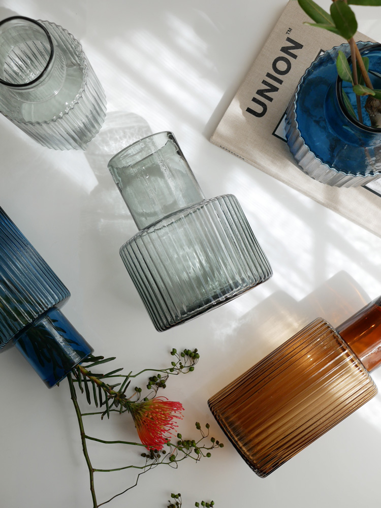 シセイのガラス製フラワーベースに美しくアレンジされた花束が飾られたセンターピース