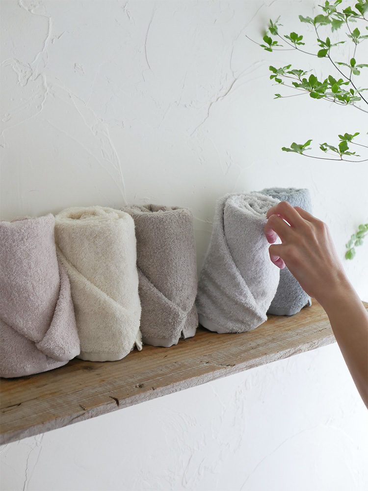 自然素材の花鉢と観葉植物に囲まれたクレシェンドの綿100％ふんわりタオルセット