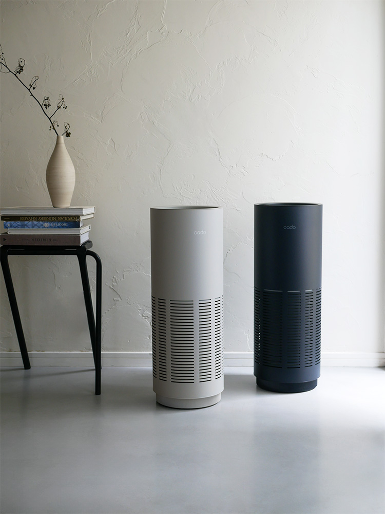 シルバー色のcado LEAF 320i空気清浄機がリビングルームの木製床に設置されている