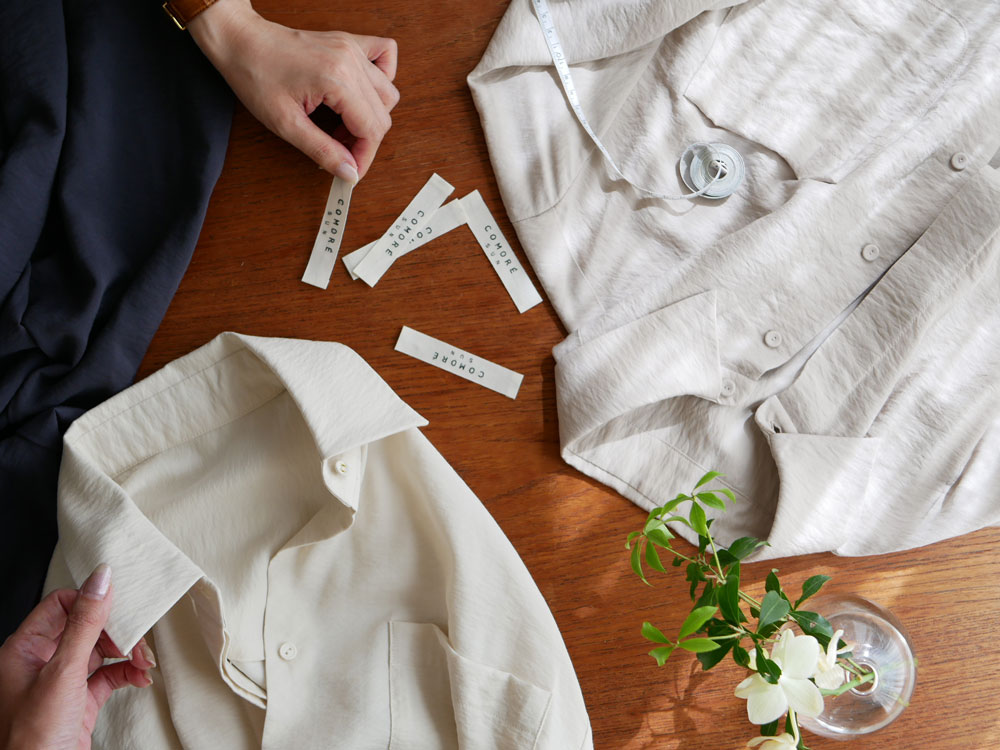 【Comore sun】オフホワイトのレーヨンシャツ。襟、ボタン、袖口が特徴的な大人カジュアルデザイン