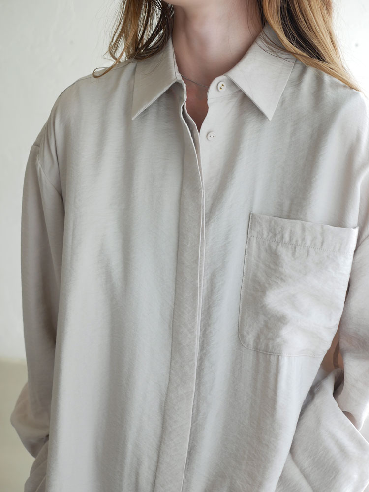Comore sunの大人向けカジュアルシャツ。オフホワイト色で襟と袖にボタン、胸ポケット付き。レーヨン84%、ナイロン16%の素材使用。