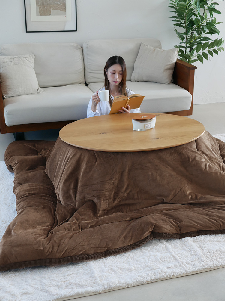 高さ調節可能な一年中使えるリビングこたつとコーヒーテーブルが配置された居心地の良いリビングルーム