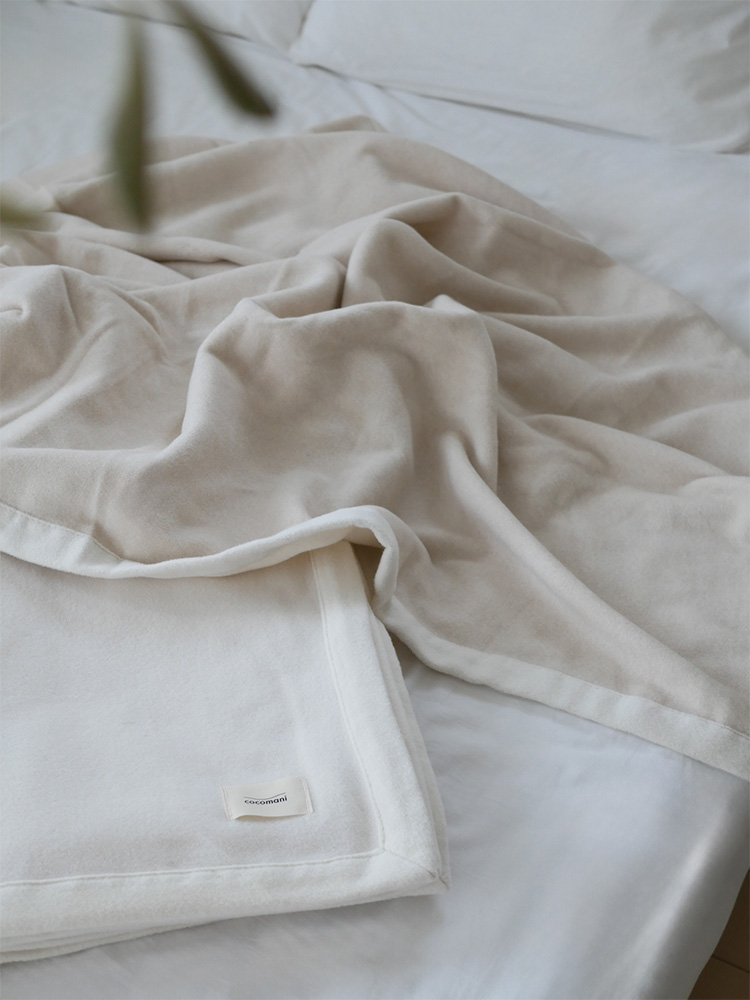 ココマニのお肌に優しいオーガニックコットン毛布がシングルサイズのベッドに掛けられている様子