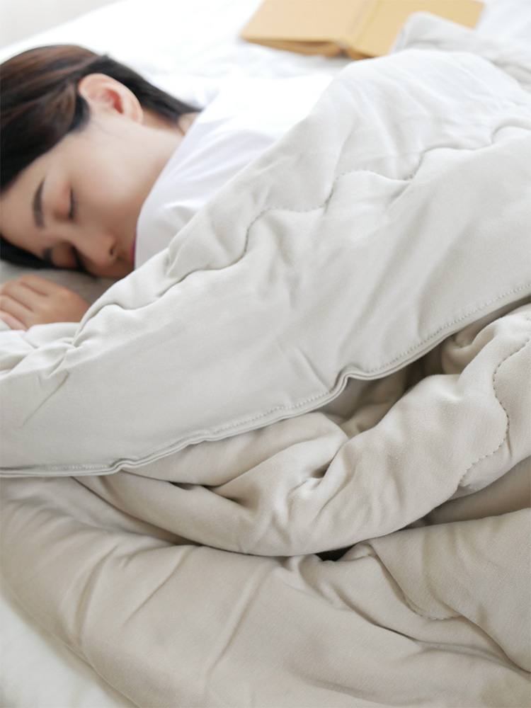 cocomaniのシングルサイズトロふわ肌掛け布団が整ったベッドにかかり、快適な寝室を演出している様子