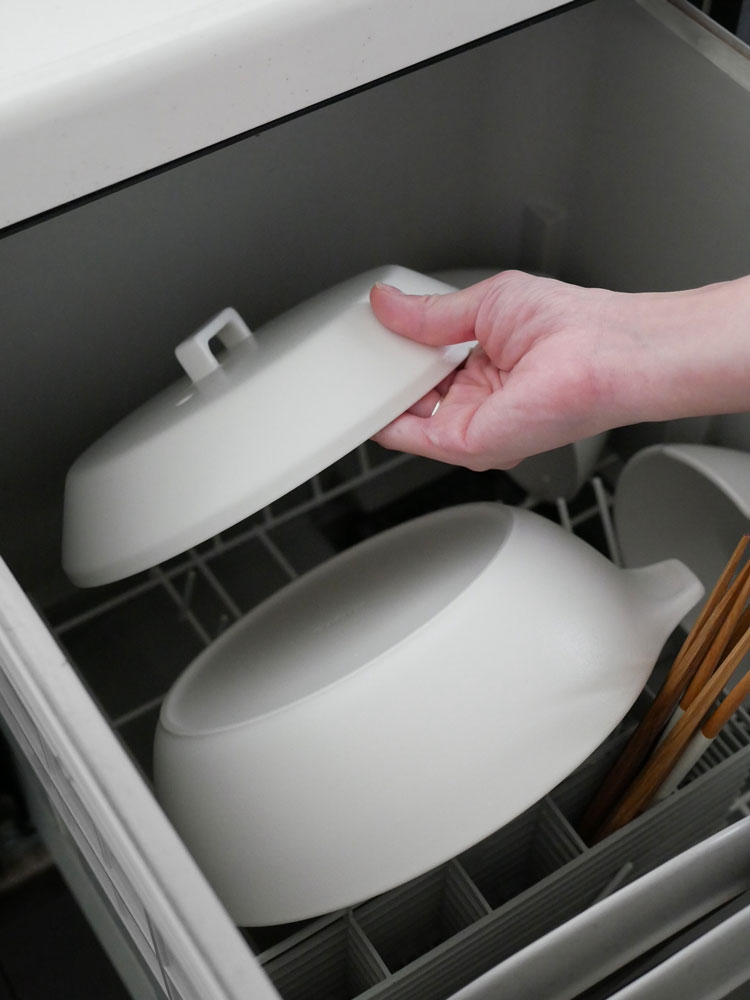 キントー KAKOMI直火土鍋と蓋が、キッチン用具や食器と共に台所に並べられている様子