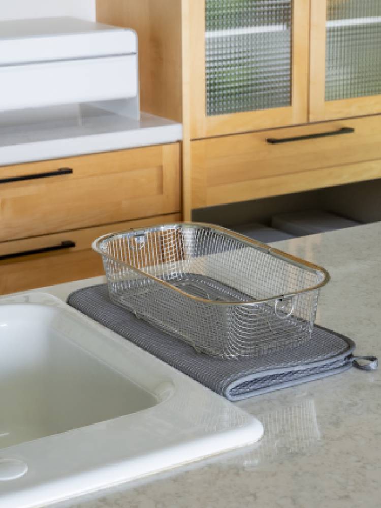 キッチンカウンターにシンクとともに配置された「すっきり暮らす水切りマット」とシルバーのメッシュディッシュラック