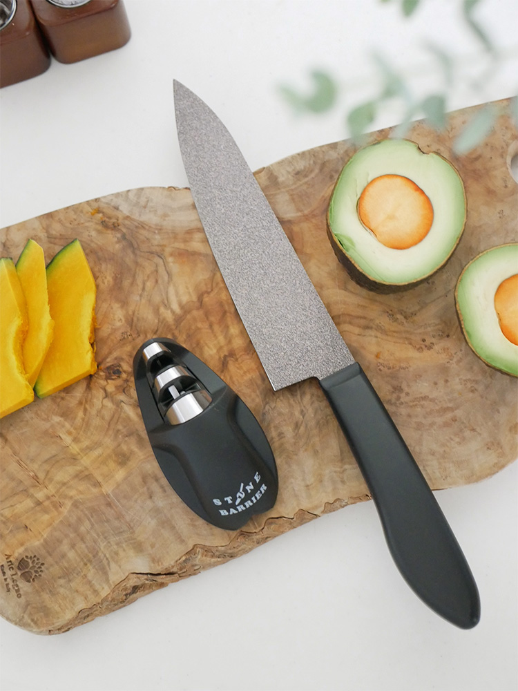 協和工業のストーンバリア包丁ライトタイプとシャープナーが、果物と一緒にまな板上に並べられている