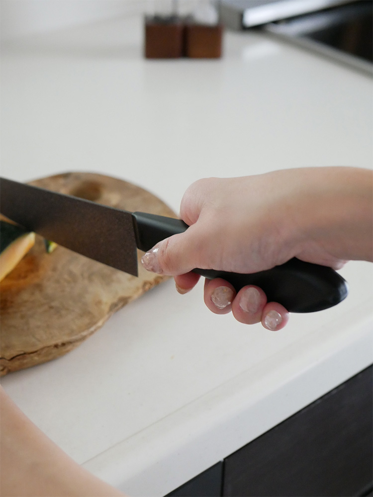 協和工業のストーンバリア包丁ライトタイプとスーパーストーンバリアシャープナーが、果物や食材と共にカッティングボード上に配置された調理セットの画像