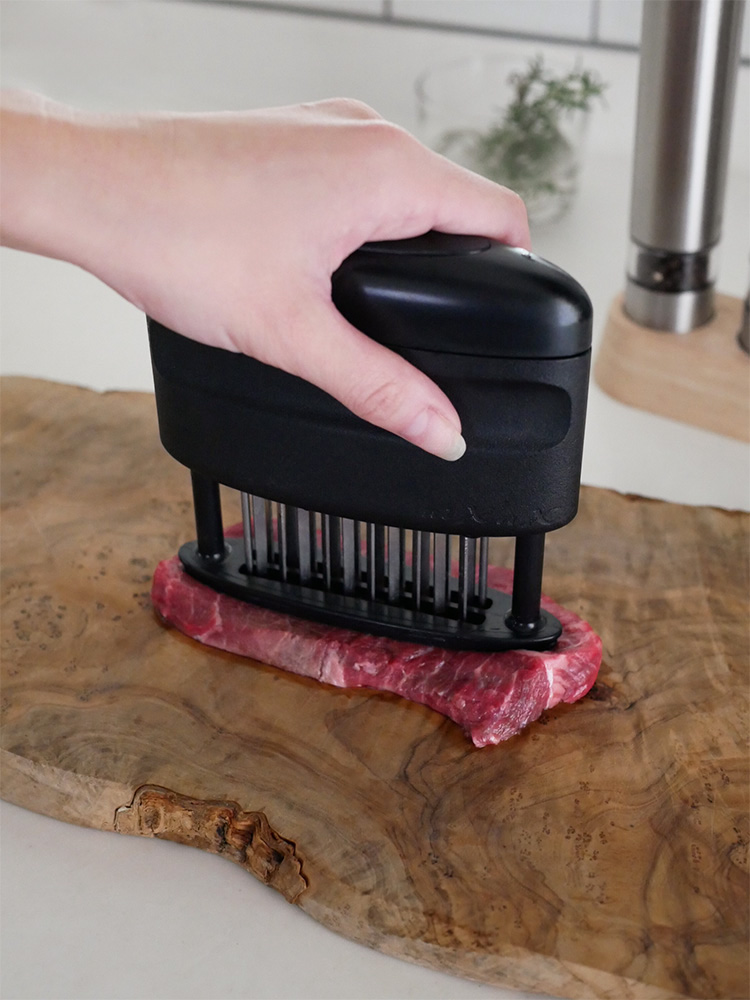 協和工業のニクサスプロを使用してまな板上の肉を柔らかくしている台所用具の写真