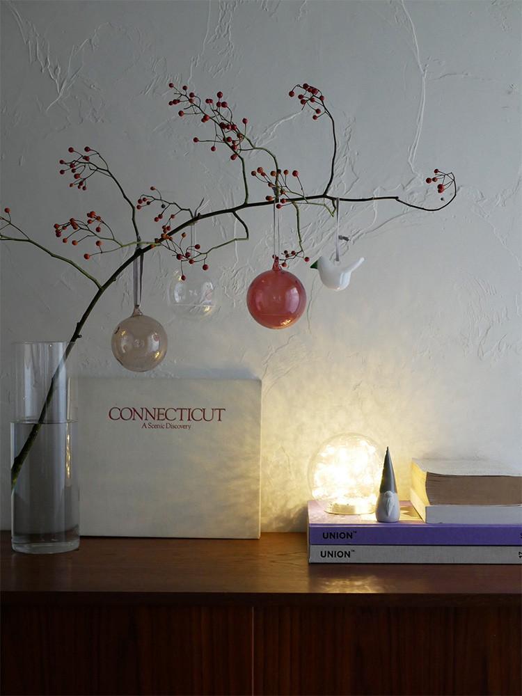 イッタラのピンク無鉛ガラスオーナメントボールが枝と小枝に飾られた静物写真