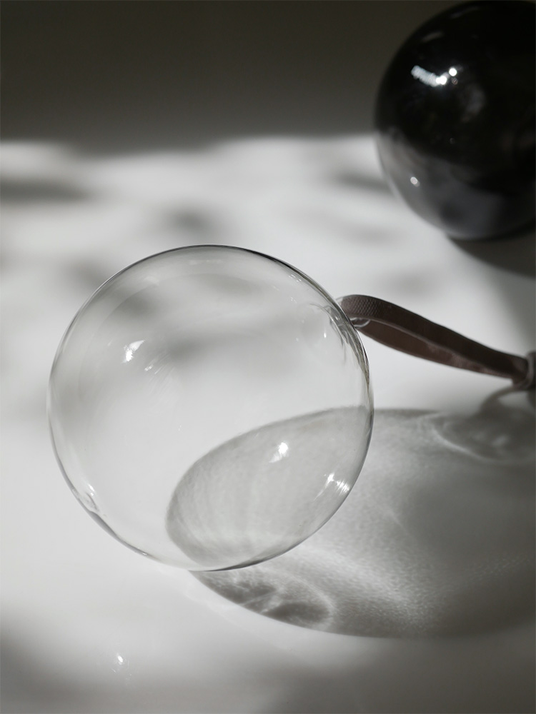 イッタラの無鉛ガラスオーナメントセット。透明な球体が反射を際立たせて配置されたモノクロの写真