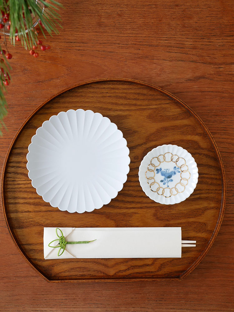 松竹梅柄の箸置き付き祝箸3膳セットとプレートや皿などの食器が整然と並べられたテーブルの写真