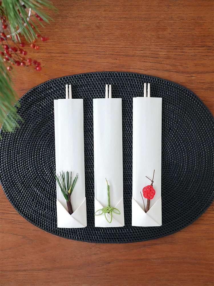 松竹梅デザインの箸置き付き祝箸3膳セットが花瓶に飾られた切り花と共に美しくテーブルに配置されています