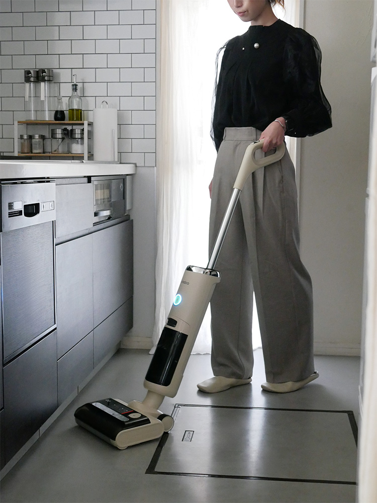 Mindoo AquaX掃除機と付属品が木製フローリングの上に配置されている画像