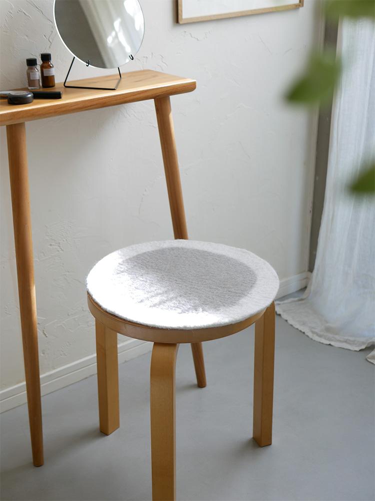 ヒナタライフのウールフェルトチェアシートを載せたハードウッド製の円筒形スツール