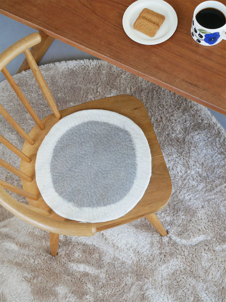 ニュージーランドウール100％のウールフェルトチェアシートがリビングルームの木製床に置かれている様子