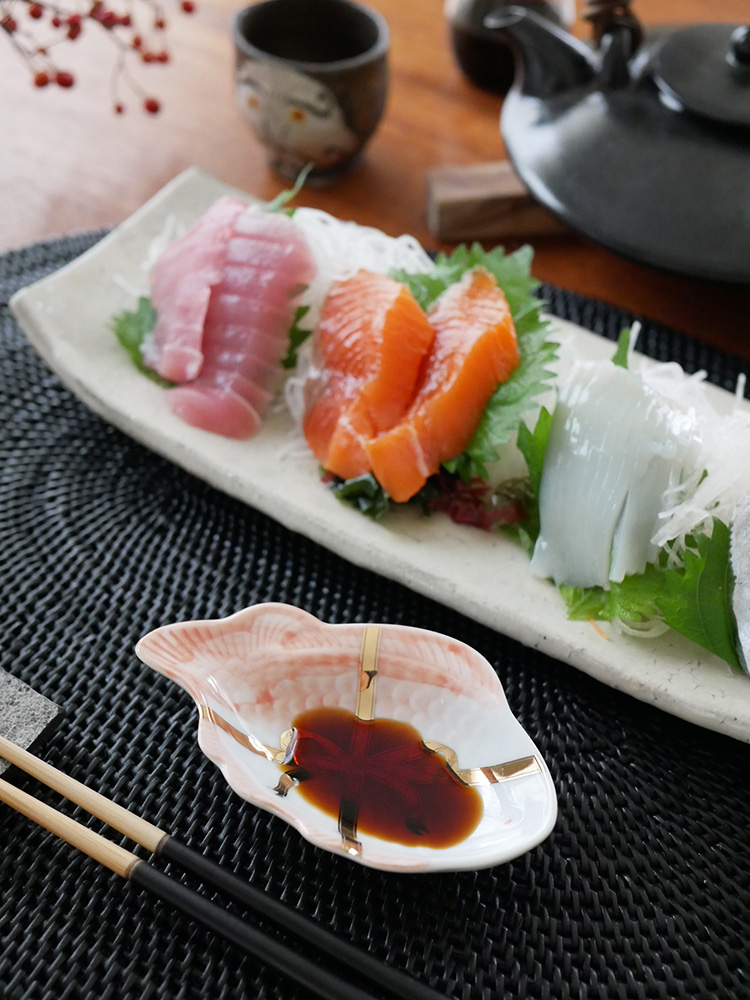 磁器製の多様な形状の皿に盛り付けられた寿司や刺身の盛り合わせ