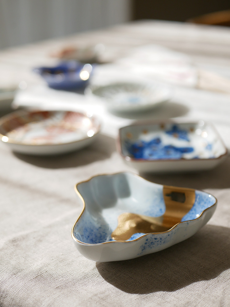 アマブロのMAMEシリーズに属する吹墨富士形皿や丸散赤丸など多様なデザインの磁器製食器が並んだセットの写真