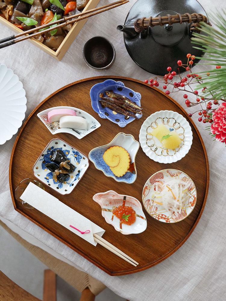 アマブロMAMEシリーズの磁器食器セットがトレイに並べられ、プレートや箸が美しく配置されたテーブルの様子