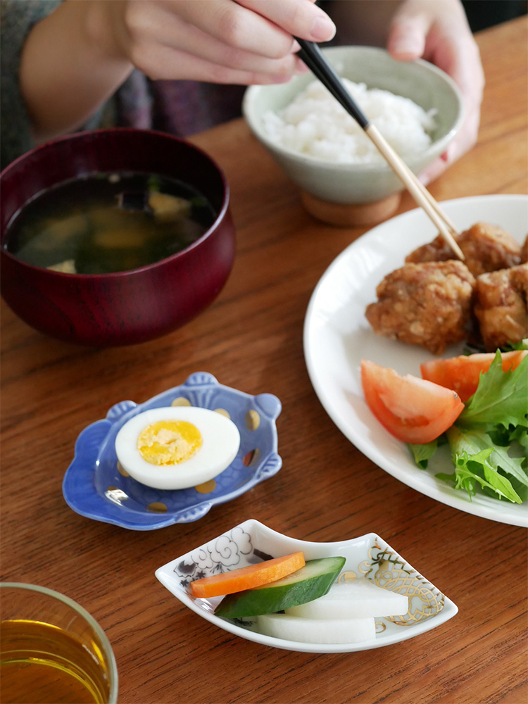 日本製の磁器食器がテーブルに美しく並べられ、色とりどりの野菜が盛り付けられています。