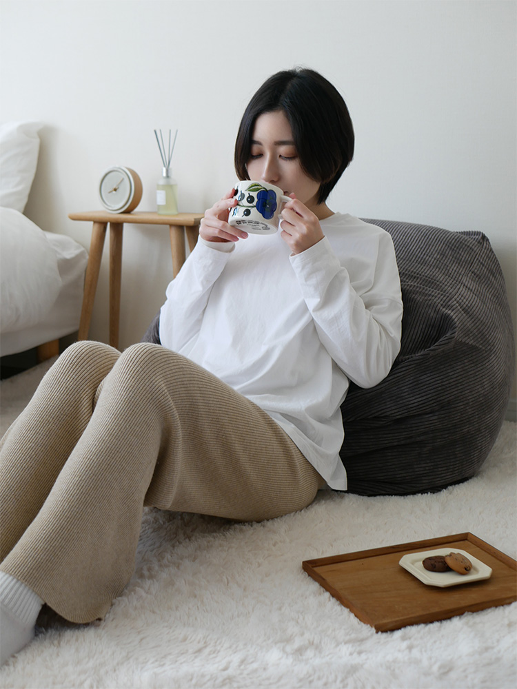 リビングルームのソファ上に置かれた【QUBE/キューブ】コーデュロイビーズクッション、快適な座り心地を提供する大型テキスタイル家具アクセサリー