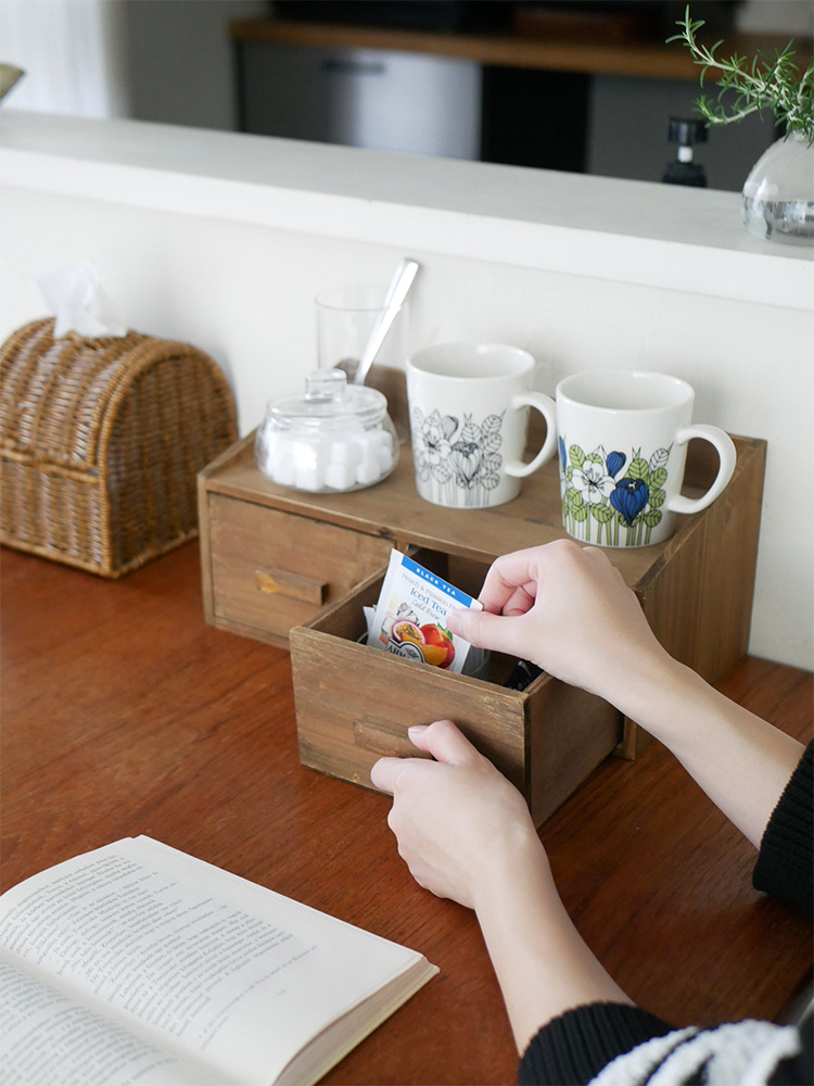 アビテ製ウッドストレージにカップやマグなどのテーブルウェアが収納されている様子