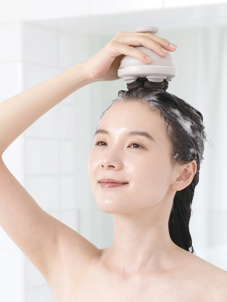 FESTINO（フェスティノ）充電式EMSヘッドスパ本体と付属ブラシがバスルームの洗面台に配置されている様子