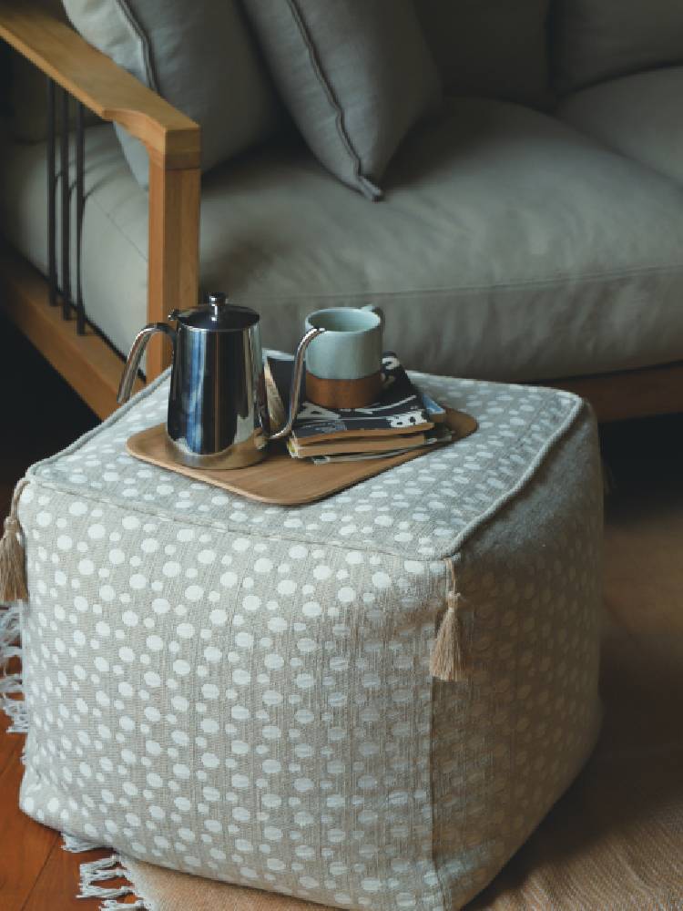 リネンカバーのアデペシュフレンチリネンビーズクッションがリビングルームのソファに配置されている様子