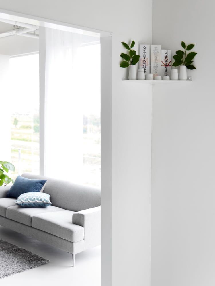リビングルームのコーナーに設置されたスチール製【tower】ウォールコーナー神棚。ソファやデイベッドと調和するモダンなインテリア