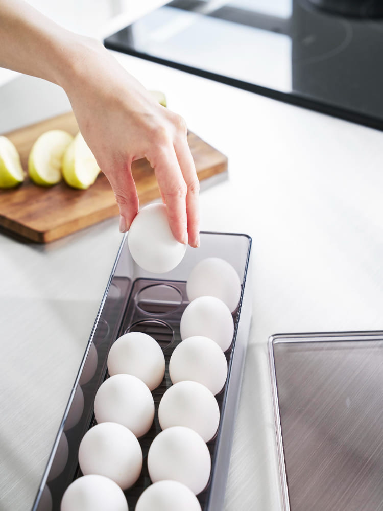 タワー冷蔵庫用中蓋付き卵ケース、ポリスチレン製で14個の卵を収納可能、冷蔵庫内の棚に設置されている