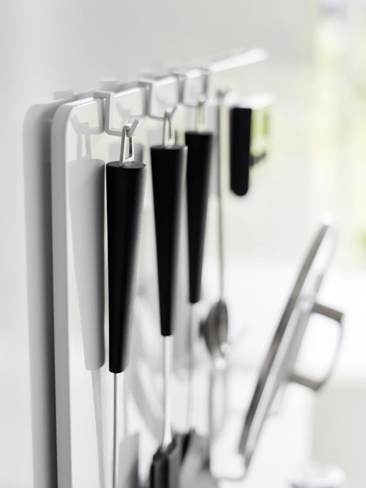 タワー フィルムフックスチールパネルにキッチン用具やカトラリーが掛かっている様子