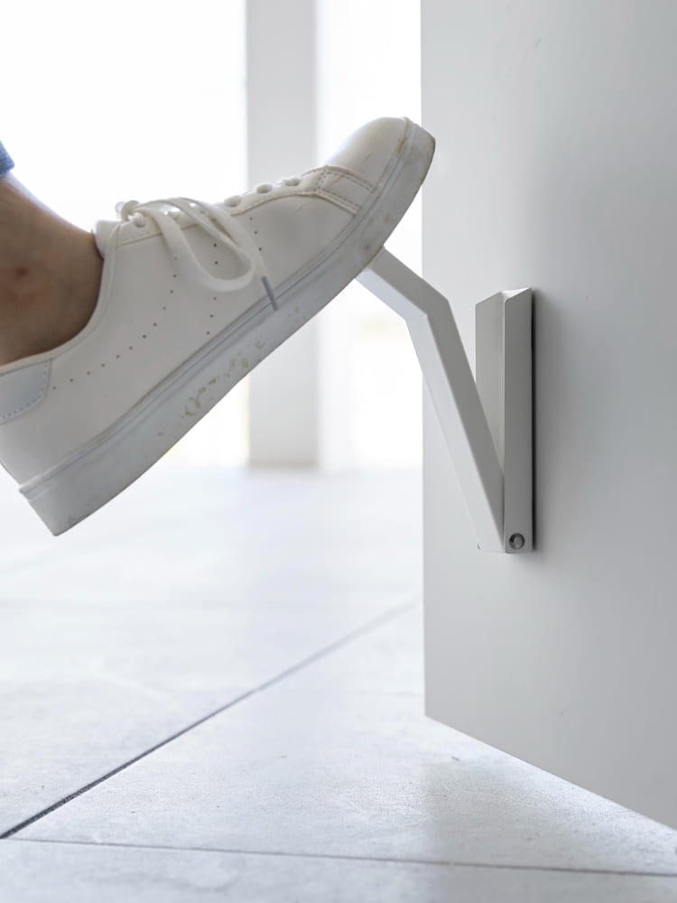 スチール製のtowerマグネット折りたたみドアストッパーがドアに取り付けられているシルバー色の様子