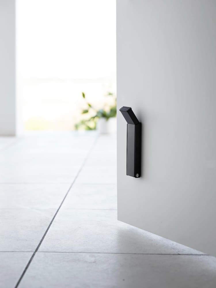 タワーマグネット折り畳みドアストッパーがスチール製のドアに取り付けられている様子