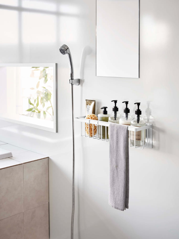 スチール製マグネットバスルームバスケットが浴室の壁に取り付けられ、タオルや日用品が掛けられている様子