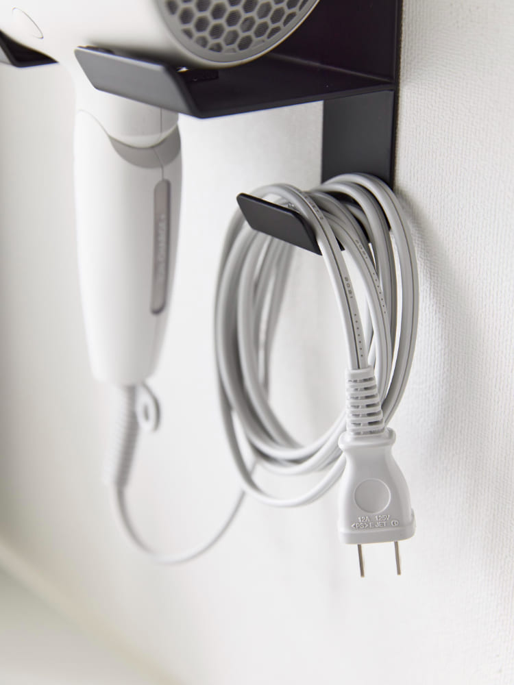 石こうボードに取り付けられたシルバーのタワー型ウォールドライヤーホルダー