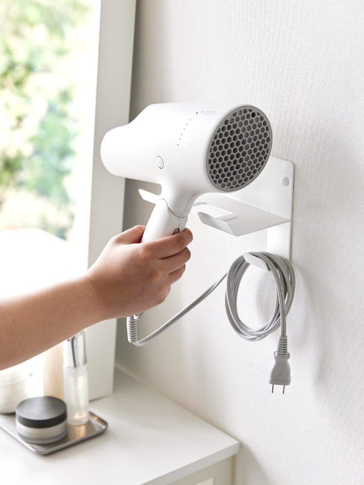 タワー石こうボード対応ウォールドライヤーホルダーにヘアドライヤーが掛けられている様子