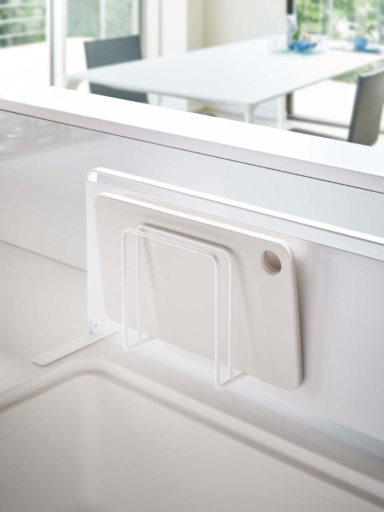 シルバーのタワーマグネットまな板スタンドが壁に取り付けられ、2枚のまな板を収納している様子