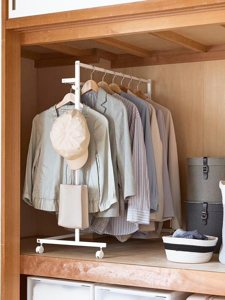 スチール製「タワー収納力アップハンガーラック」が室内のクローゼットに配置され、複数のハンガーバーと棚で整理整頓されている様子。