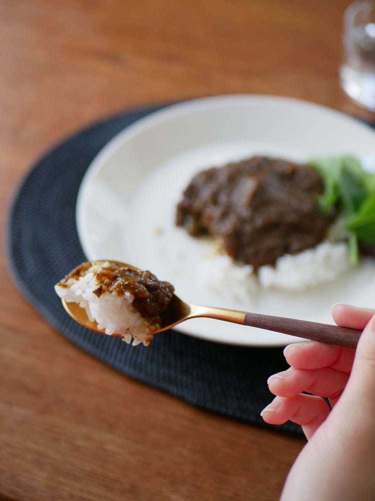 Cutipol MIOシリーズのブラウンゴールドとグレーシルバーのカトラリーセットが整然と並べられたダイニングテーブル